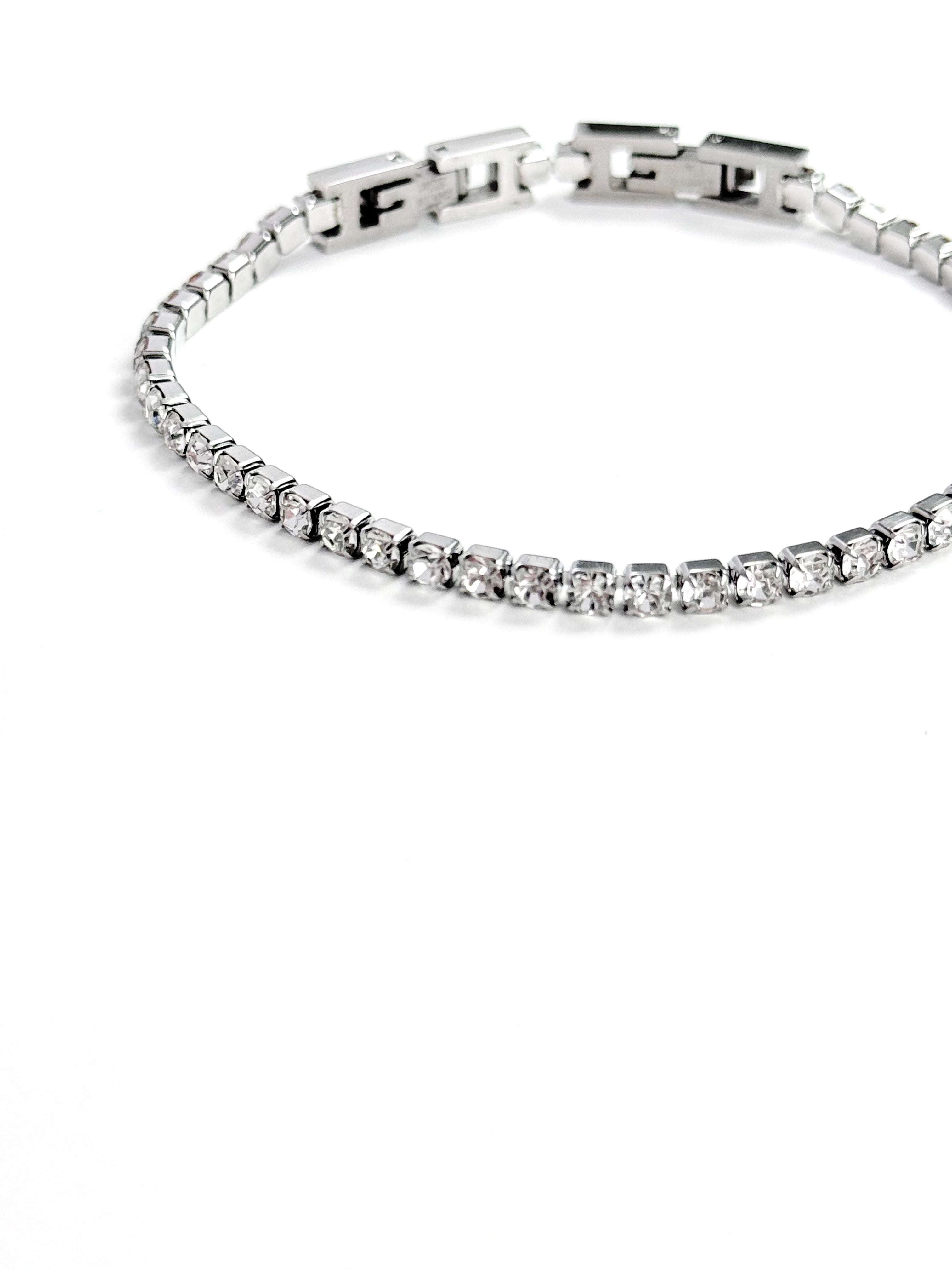 A silver tennis bracelet with clear cubic zirconia stones, shown on a plain white background.