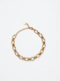 A gold-toned metal chain link bracelet with elongated oval links and a small extender chain with a round tag, shown on a plain white background.