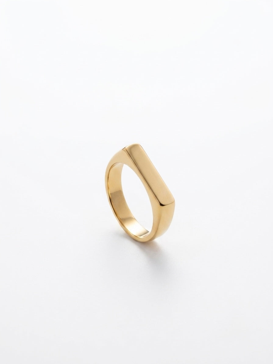 A polished gold signet ring with a flat, rectangular face, shown on a clean white background.