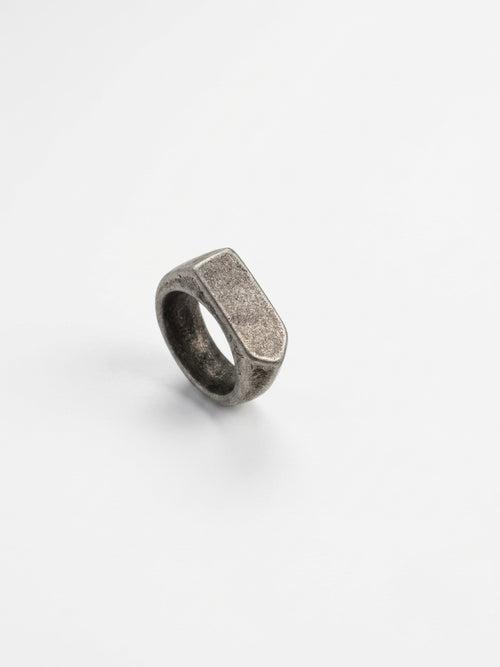 A textured silver signet-style ring with a rectangular face, photographed on a clean white background.